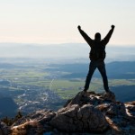 Happy mountaineer standing on the top